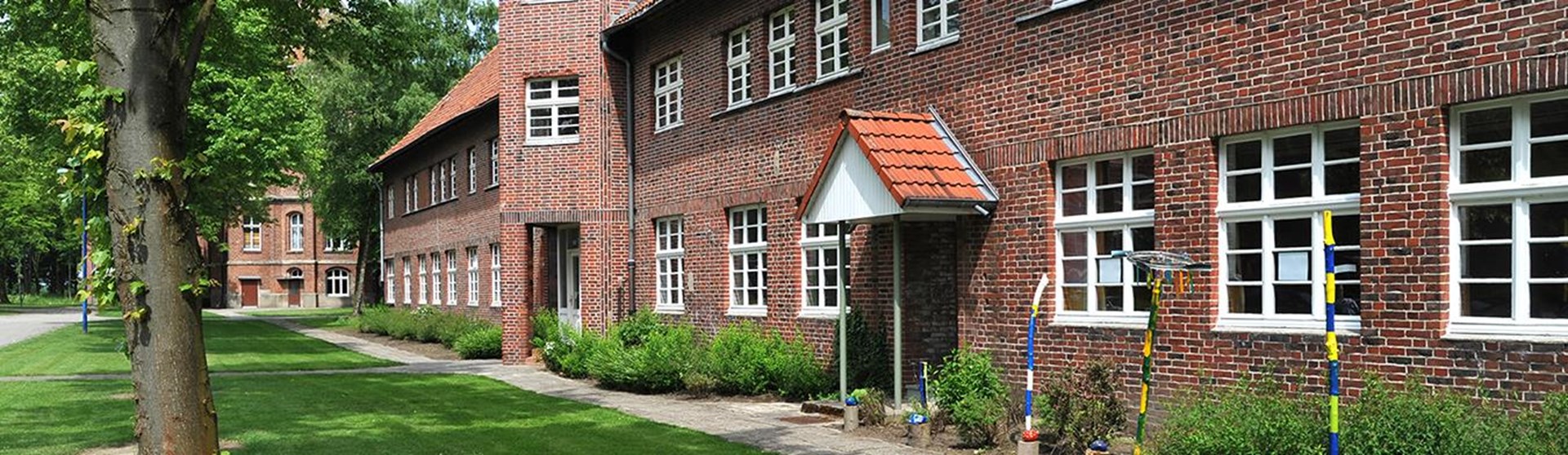 Gebäude mit Eingangsbereich und Baum