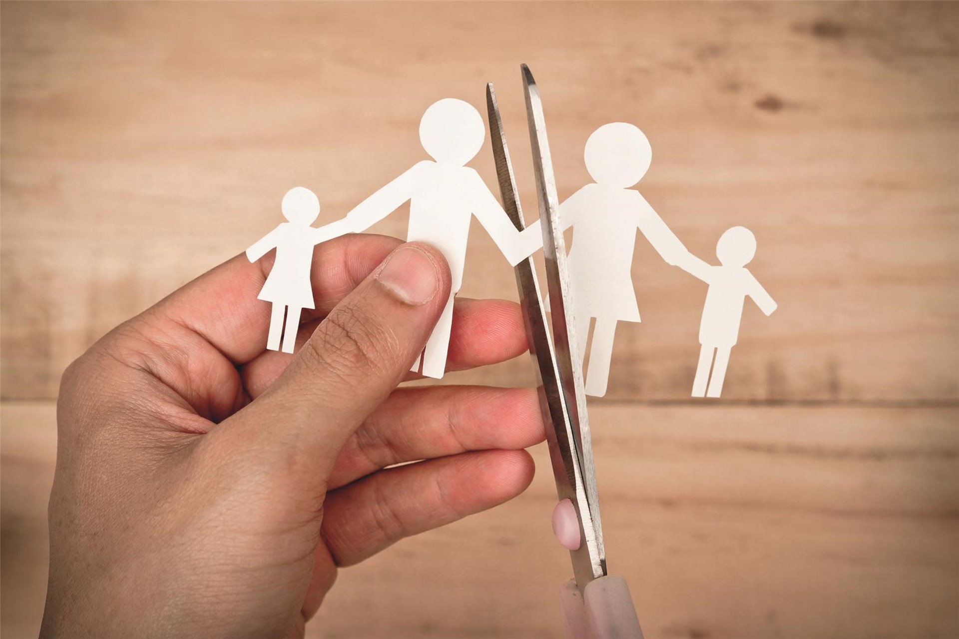 Figuren aus Papier werden mit einer Schere auseinander geschnitten
