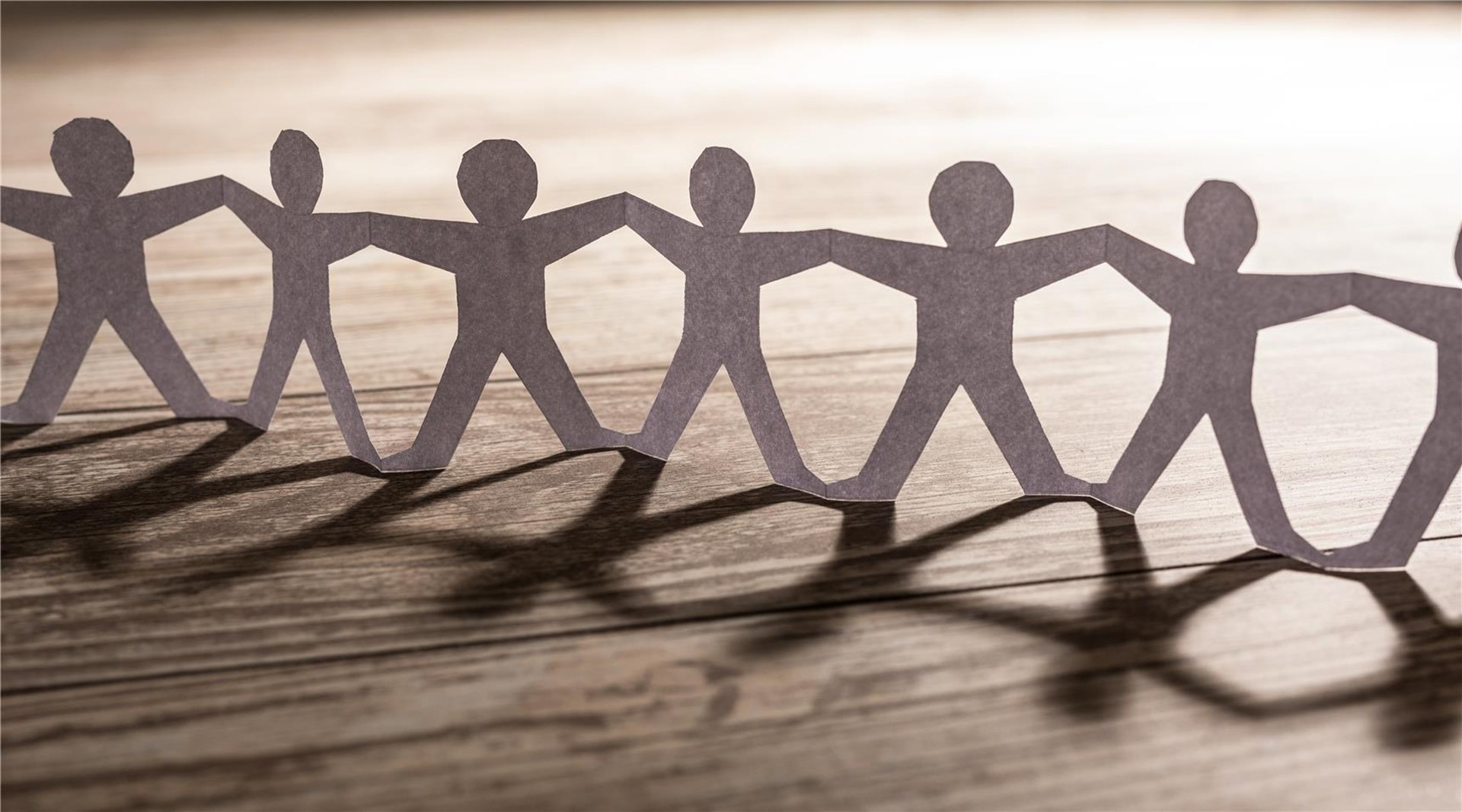 Eine Papiergirlande aus Menschen, die an Händen und Füßen verbunden ist