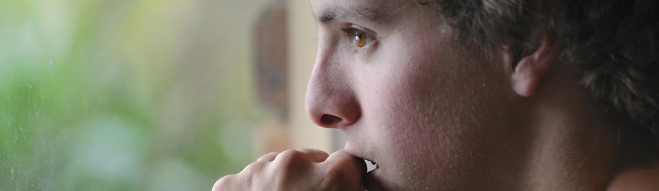 Frau schaut gedankenverloren aus dem Fenster