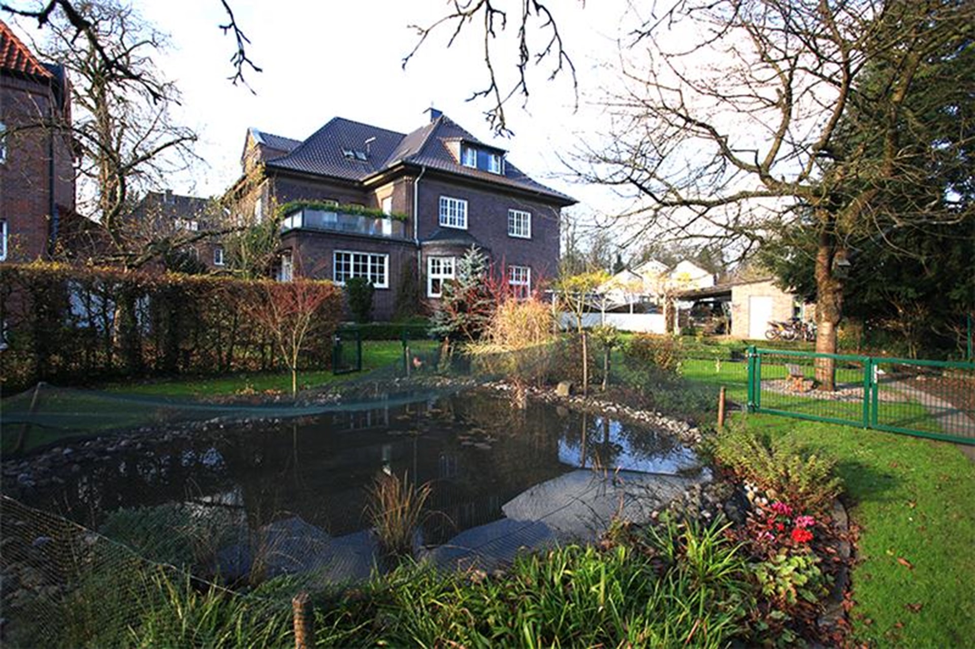 Gartenlandschaft mit Gebäude im Hintergrund.