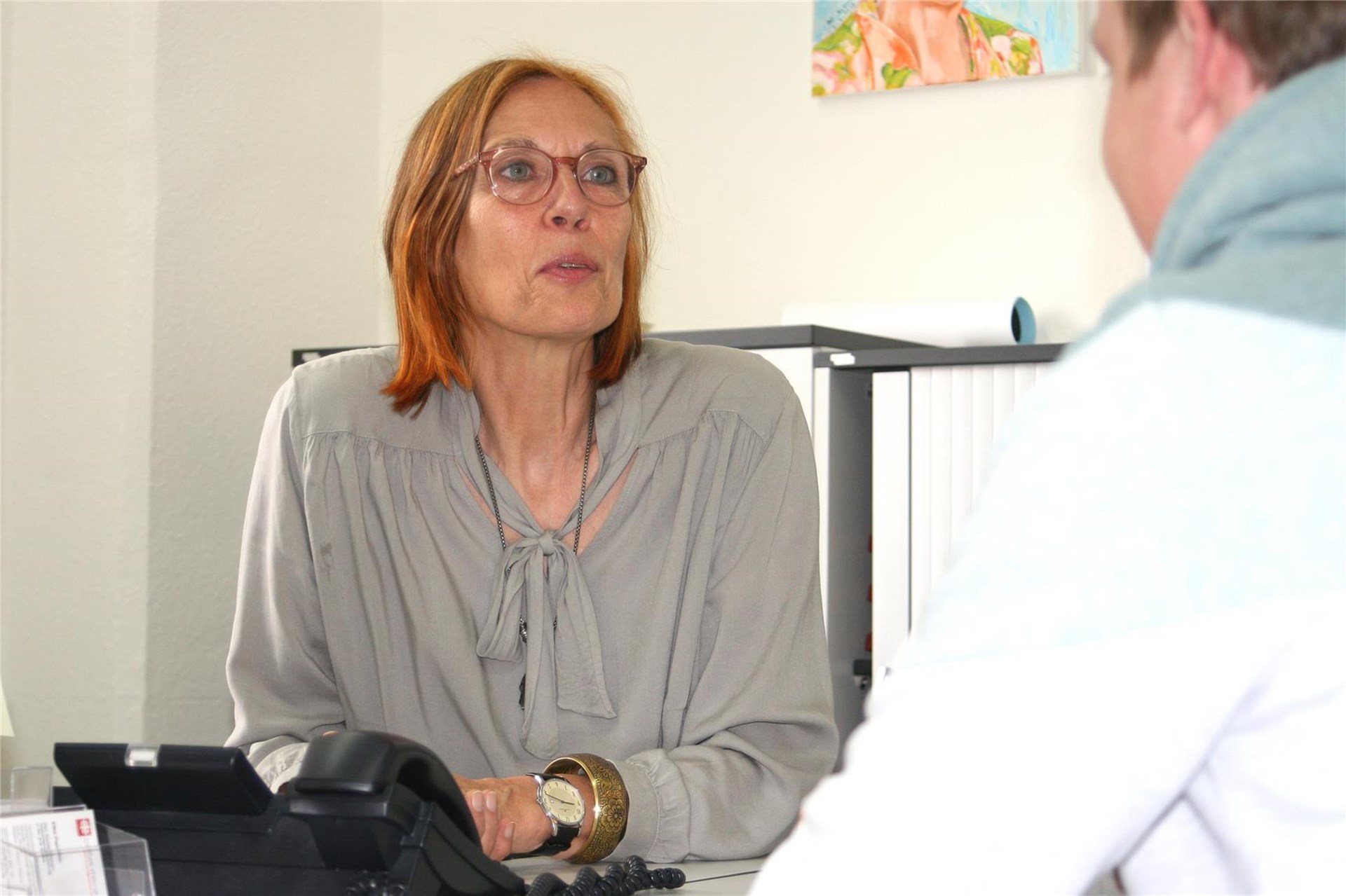 Eine Frau sitzt hinter einem Schreibtisch