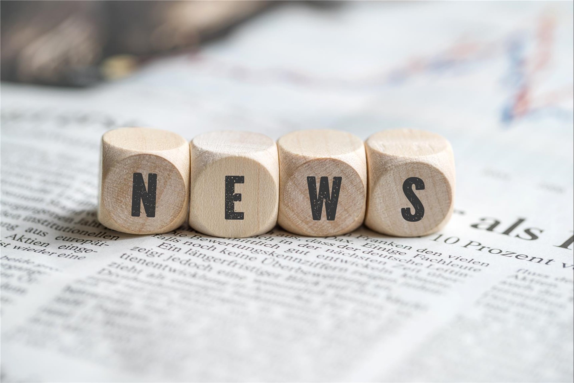 Vier Würfel in einer Reihe, die den Schriftzug News zeigen