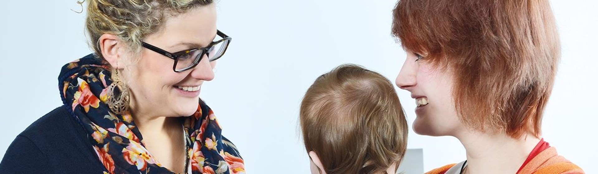 Eine Frau steht einer Frau mit Baby gegenüber