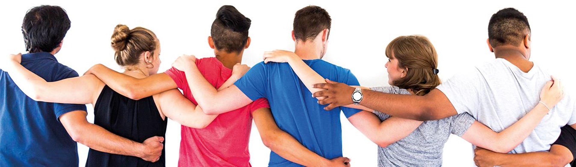 Junge Erwachsene stehen Arm in Arm, zu sehen von hinten