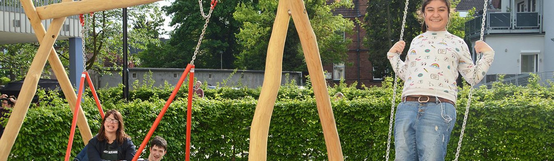 Drei Jugendliche auf einer Schaukel
