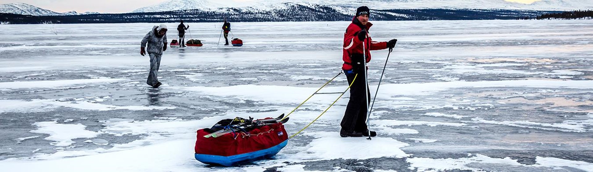 Vier Personen laufen auf einem zugefrorenen See