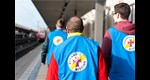 Mitarbeiter der Bahnhofsmission laufen über den Bahnsteig.